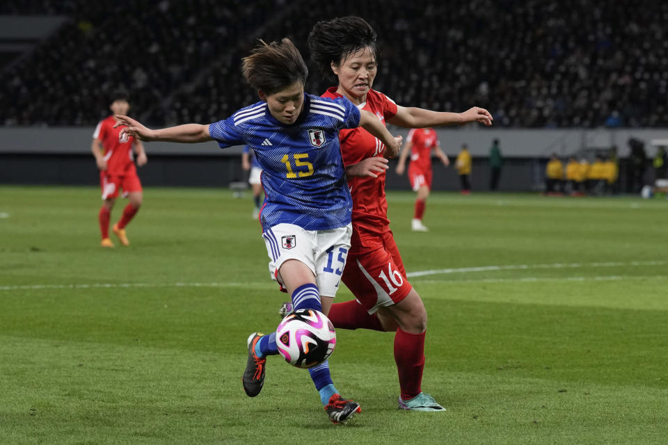 Japan's Aoba Fujino, left, and North Korea's Pak Sin Jong compete for the ball during the final qualifier for the Paris Olympic women's football tournament at the National Stadium Wednesday, Feb. 28, 2024, in Tokyo. (AP Photo/Eugene Hoshiko)