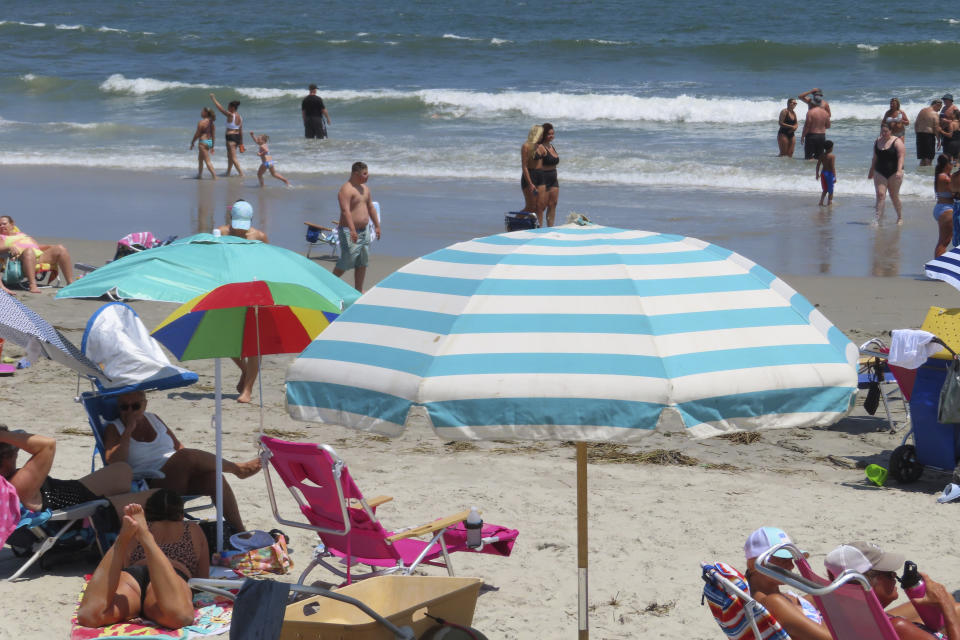 Beachgoers enjoy the sand and surf in North Wildwood N.J. on July 7, 2023. A recent winter storm in January 2024 punched a hole through what is left of the city's eroded dune system, leaving it more vulnerable than ever to destructive flooding as the city and state fight in court over how best to protect the popular beach resort. (AP Photo/Wayne Parry)