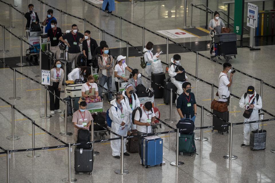 Travellers waiting in line for shuttle bus to quarantine hotels inside Hong Kong International Airport on July 7, 2022 in Hong Kong, China. The Hong Kong Government announce that it will suspend the Covid-19 flight ban mechanism which ban flights carrying more than 5 Covid-19 positive passengers to fly to the city for five days. (Photo by Vernon Yuen/NurPhoto via Getty Images)