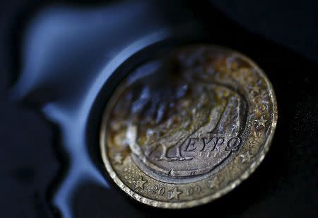 A one Euro coin with a Greek owl is seen burning in this picture illustration taken in Hanau, Germany July 3, 2015. REUTERS/Kai Pfaffenbach -