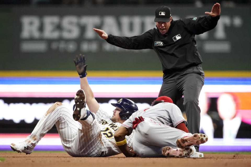 Milwaukee Brewers' Hunter Renfroe, left, slides in safely at second base past the tag of Cincinnati Reds' Jose Barrero, right, during the eighth inning of a baseball game Saturday, Sept. 10, 2022, in Milwaukee. (AP Photo/Aaron Gash)