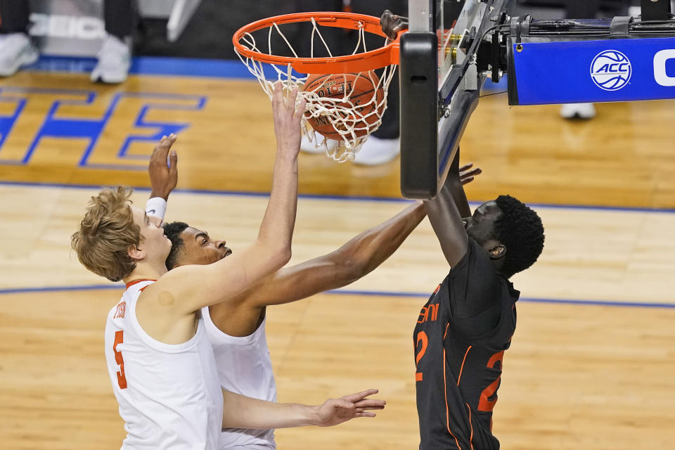 Miami guard Isaiah Wong (2) dunks in front of Clemson forward Hunter Tyson (5) and teammate Clemson guard Clyde Trapp, center, during the second half of an NCAA college basketball game in the second round of the Atlantic Coast Conference tournament in Greensboro, N.C., Wednesday, March 10, 2021. (AP Photo/Gerry Broome)