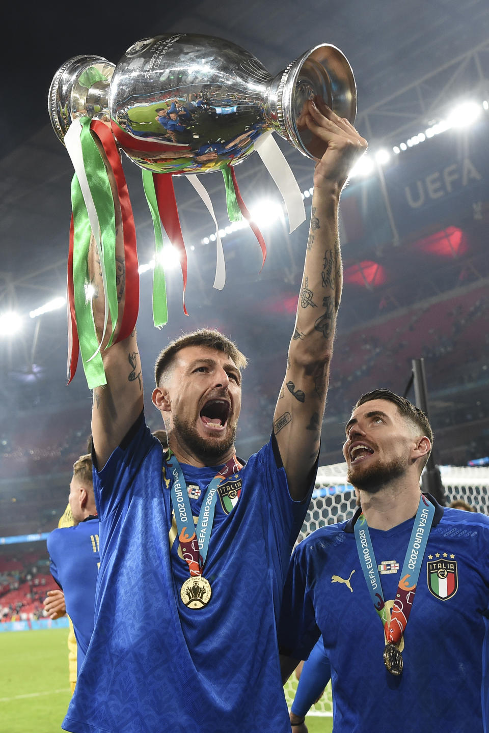 Italy's Francesco Acerbi holds up the trophy after the final of the Euro 2020 soccer final match between England and Italy at Wembley stadium in London, Sunday, July 11, 2021. (Andy Rain/Pool Photo via AP)