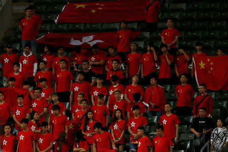 Fans supporting Hong Kong and mainland China stand with flags during Chinese national anthem, at the Asian Cup preliminary match between Hong Kong and Lebanon in Hong Kong, China November 14, 2017. REUTERS/Bobby Yip