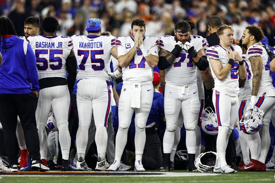 Josh Allen #17 of the Buffalo Bills and teammates react to an injury sustained by Damar Hamlin #3 during the first quarter of an NFL football game against the Cincinnati Bengals