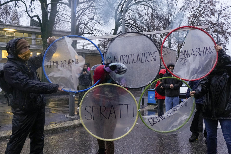 Activists of the C.I.O Comitato Insostenibili Olimpiadi (Unsustainable Olympics Commetee) smash signs in Italian reading: "Concreting, privatization, eviction" as they march in front of the building site of the 2026 Winter Olympic village in Milan, northern Italy, Saturday, Feb. 10, 2024, to protest the prospected costs of the 2026 Winter Olympics that will be disputed in Milan and Cortina d'Ampezzo in the Dolomites. (AP Photo/Luca Bruno)