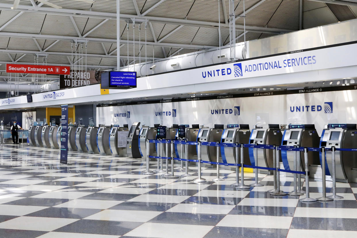 FILE - In this June 25, 2020, file photo, rows of United Airlines check-in counters at O'Hare International Airport in Chicago are unoccupied amid the coronavirus pandemic. On Sunday, Aug. 30, 2020, United Airlines says it will be dropping an unpopular $200 fee for most people who change a ticket for travel within the United States. (AP Photo/Teresa Crawford, File)