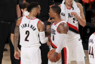 Portland Trail Blazers' Gary Trent Jr.(2) and Damian Lillard (0) react after defeating the Memphis Grizzlies in overtime of an NBA basketball game Friday, July 31, 2020, in Lake Buena Vista, Fla. (Mike Ehrmann/Pool Photo via AP)