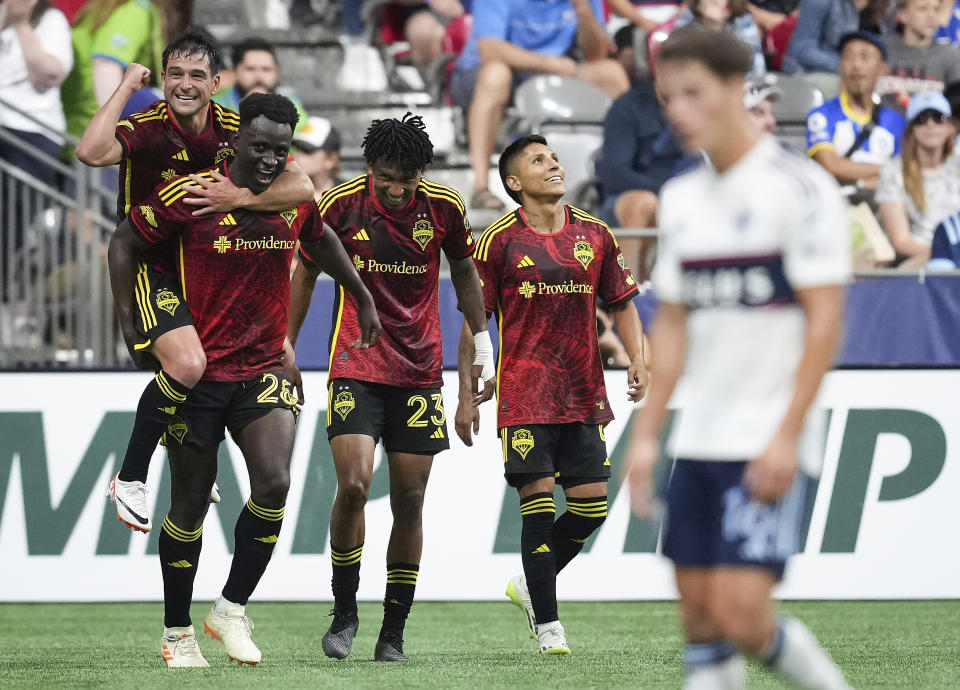 Seattle Sounders' Nicolas Lodeiro, Yeimar Gomez, Leo Chu and Raul Ruidiaz, from left, celebrate Gomez's goal against the Vancouver Whitecaps during the second half of an MLS soccer match Saturday, July 8, 2023, in Vancouver, British Columbia. (Darryl Dyck/The Canadian Press via AP)