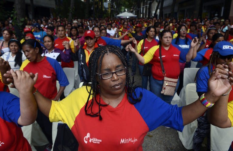 Supporters of Venezuelan President Hugo Chavez pray during a mass in the center of Caracas, on December 11, 2012. Chavez is now recovering after a successful cancer operation at a Cuban hospital, according to his vice president