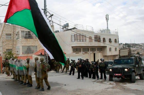 Israeli troops face Palestinian protesters during a demonstration commemorating 18 years to the Hebron massacre and calling to open Shuhada street in the West Bank city of Hebron, Feb. 24, 2012. <span class="copyright">Nasser Shiyoukhi—AP</span>