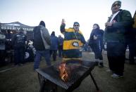 Edmonton Eskimos fans keep warm before the CFL's 103rd Grey Cup championship football game between the Ottawa Redblacks and the Eskimos in Winnipeg, Manitoba, November 29, 2015. REUTERS/Lyle Stafford