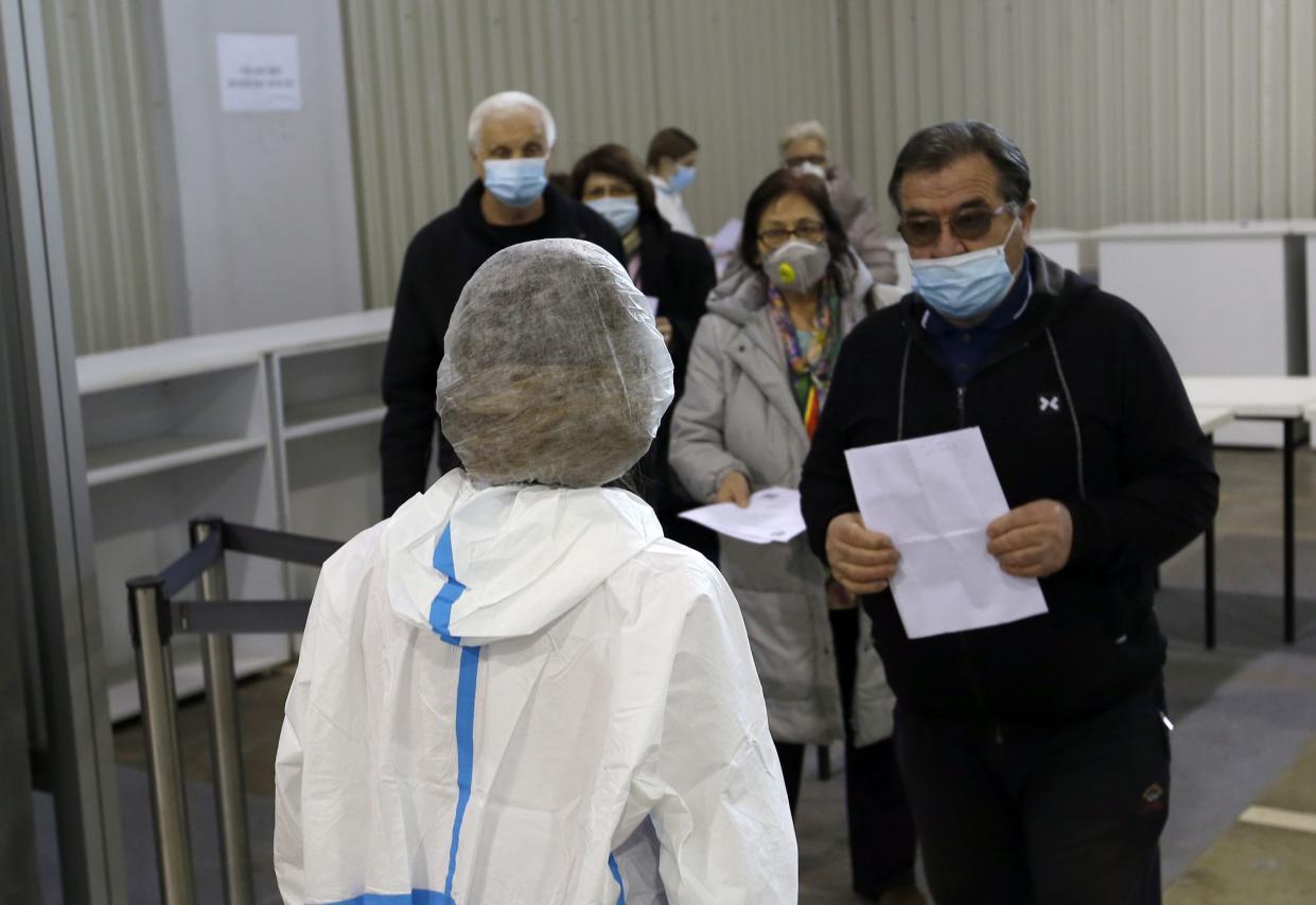 People wait in line to receive a dose of the Chinese Sinopharm COVID-19 vaccine at Belgrade Fair makeshift vaccination center in Belgrade, Serbia, on Wednesday, Feb. 17, 2021. Serbian health expert Chief epidemiologist Predrag Kon on Tuesday, March 2, 2021, called for the government to introduce a state of emergency and a strict lockdown to halt a surge in coronavirus infections in the Balkan country.