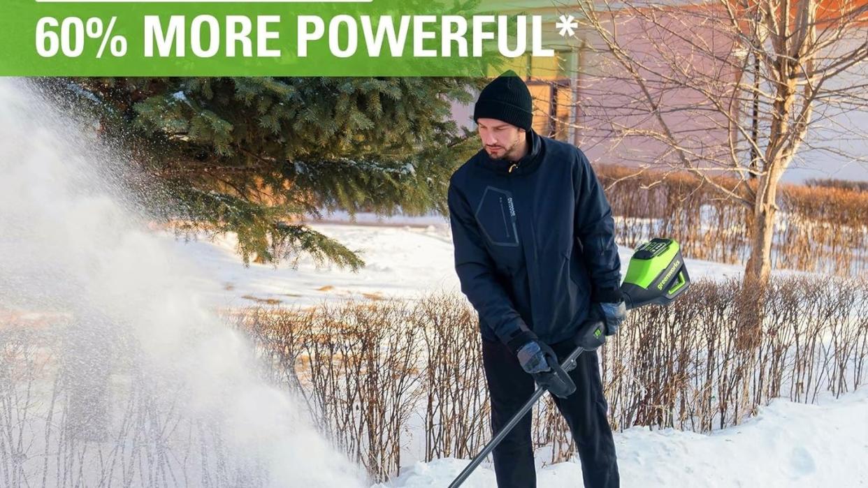 man shoveling snow with greenworks electric snow shovel