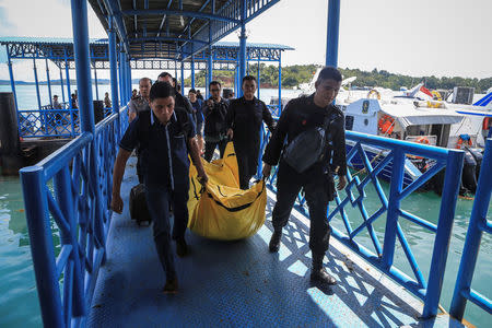 Police carry a body bag containing debris and belongings recovered from an aircraft carrying 13 police personnel which went missing on Saturday, in Batam, Riau Islands, Indonesia December 4, 2016 in this photo taken by Antara Foto. Antara Foto/M N Kanwa/via REUTERS