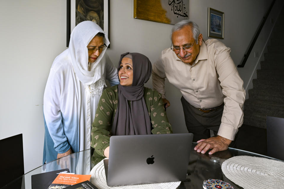 Muslim family members Saadiha, seated, Saeeda, and Abdul Khaliq, right, gather around a computer which they use to research for their hajj trip, pictured Wednesday, June. 7, 2023, in Murfreesboro, Tenn. The Khaliq family are planning to travel together to Mecca in Saudi Arabia for hajj, pilgrimage which every adult Muslim who can afford it and is physically able must make at least once in his or her lifetime. The hajj is the fifth of the fundamental Muslim practices and institutions known as the Five Pillars of Islam. (AP Photo/John Amis)