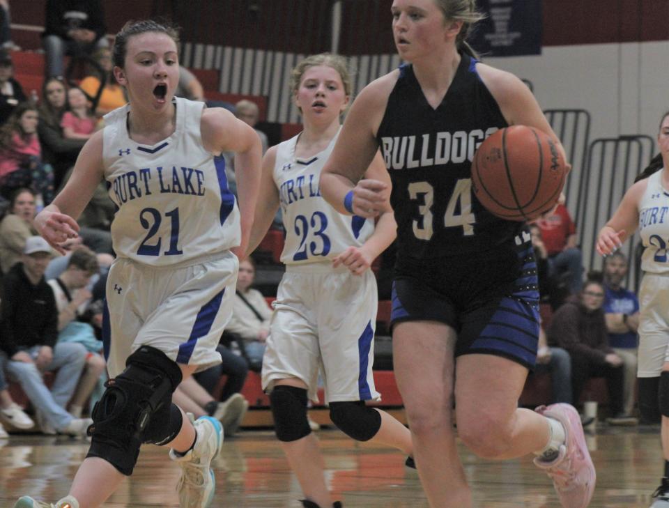 Inland Lakes sophomore guard Molly Monthei (34) drives to the basket while Burt Lake NMCA's Addie Pietrowski (21) chases during the first half of Wednesday's MHSAA Division 4 district semifinal in Onaway.