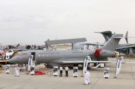 Visitors walk past a GlobalEye aircraft, manufactured by Saab Technologies, on static during the fifth day of Dubai Air Show in Dubai