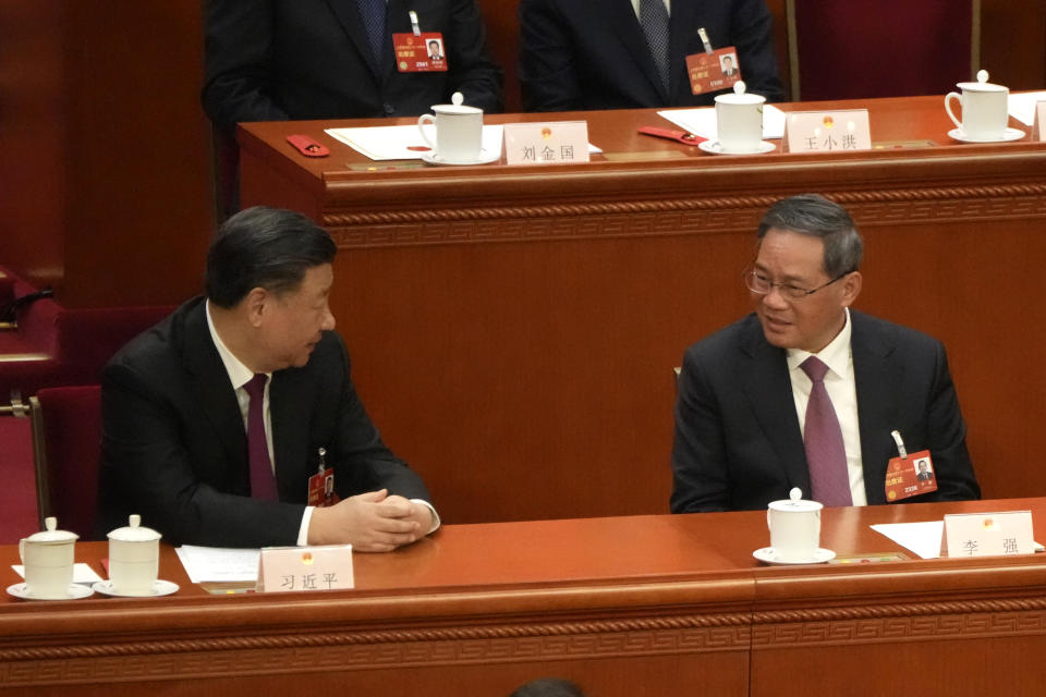 Chinese President Xi Jinping at left chats with Li Qiang during a session of China's National People's Congress (NPC) to select state leaders at the Great Hall of the People in Beijing, Friday, March 10, 2023. (AP Photo/Mark Schiefelbein)