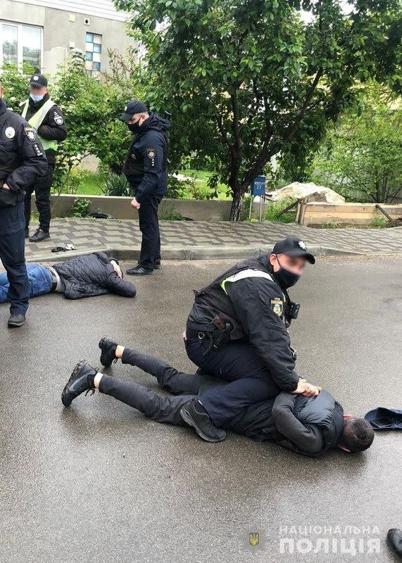 Police officers detain men suspected of taking part in a recent armed conflict in Brovary