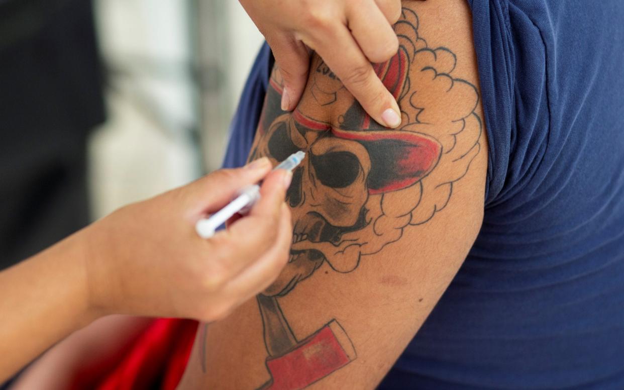 A fireman receives a dose of the Oxford-AstraZeneca vaccine in Guatemala City - LUIS ECHEVERRIA /REUTERS