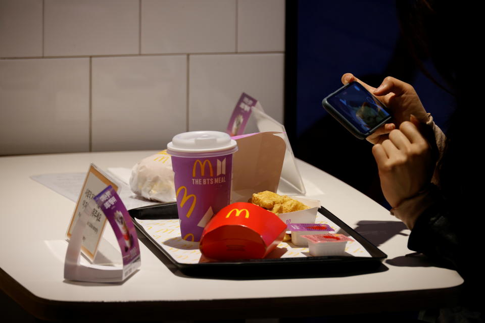 A fan of K-pop boy band BTS takes a souvenir picture of a McDonald's BTS meal, during lunch hour at its restaurant in Seoul, South Korea, May 27, 2021.  REUTERS/Kim Hong-Ji