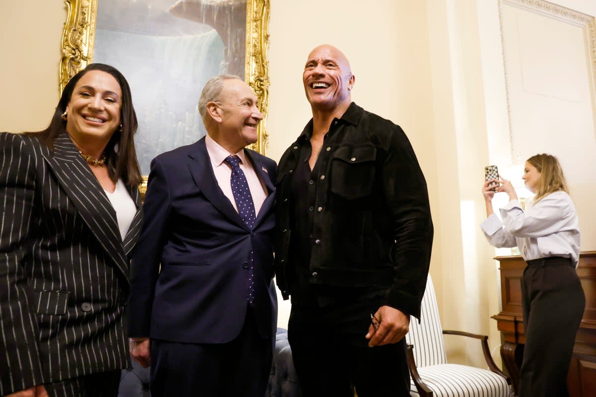 Senate Majority Leader Chuck Schumer (D-NY) poses for photos with actor Dwayne Johnson (R) and XFL Co-Owner and CEO Dany Garcia (L) in his office at the U.S. Capitol Building on 15 November 2023 in Washington DC. (Getty Images)