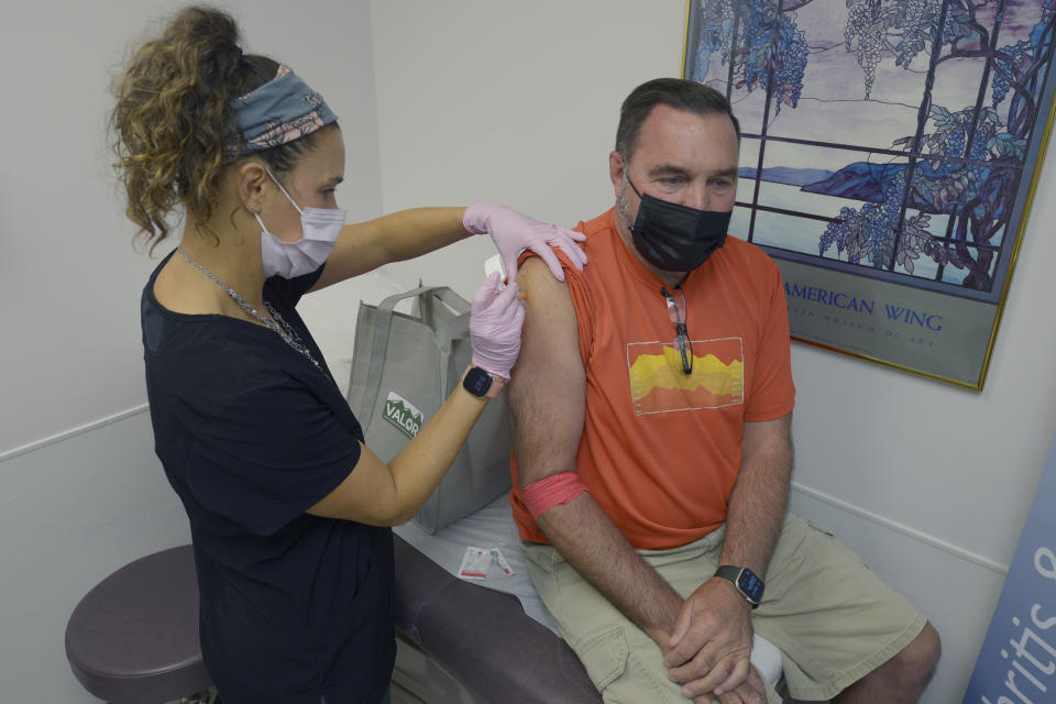 Robert Terwilliger, right, of Williamsburg, Pa., who is participating in a Lyme disease vaccine trial at the Altoona Center for Clinical Research, is injected with either the new vaccine or a placebo, by registered nurse Janae Roland, Friday, Aug. 5, 2022, in Duncansville, Pa. Lyme is a growing problem, with cases steadily rising and warming weather helping ticks expand their habitat. (AP Photo/Gary M. Baranec)