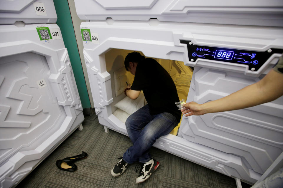 A staff member gives mute earplugs to a customer as he prepares to sleep in a capsule bed unit at Xiangshui Space during lunch break in Beijing's Zhongguancun area, China July 11, 2017. REUTERS/Jason Lee