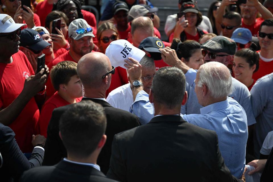 US President Joe Biden swaps hats with a member of the crowd after speaking during Labor Day celebrations in Philadephia, Pennsylvania, August 4, 2023.