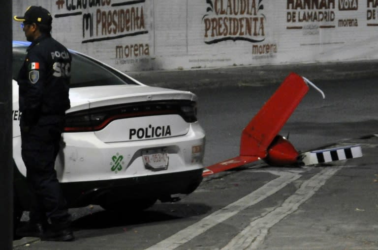 Un fragmento del helicóptero accidentado, junto a un policía que acudió al lugar del siniestro mortal, el 14 de abril de 2024 en Ciudad de México (Miguel Romero)