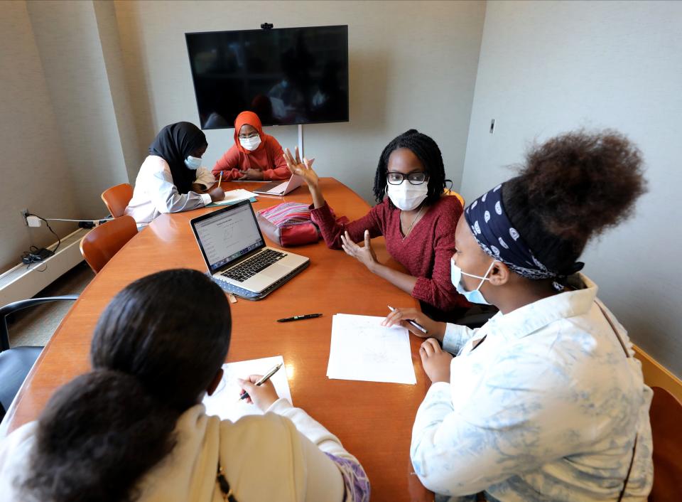 Sayidana Brannan-Douglas, right center, tutors Simone Brannan, 15, left, and Tiara Kidd, 15, in geometry as Ndeye Aida Wade, rear center, from the New School for Leadership and The Arts in the Bronx, New York, tutors Sagar Sarr, 13, from the Walter Panas School in Cortlandt Manor, N.Y. during a math tutoring session held by the Sister to Sister International, Inc., at the Yonkers Public Library, Oct 23, 2021. 