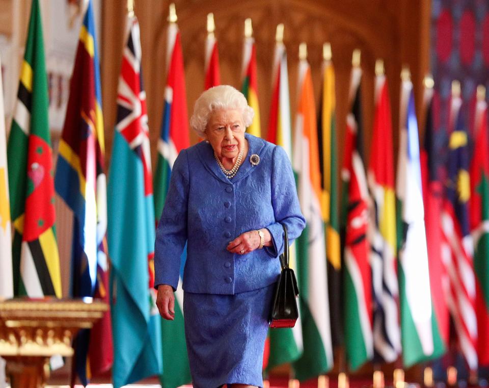 Britain's Queen Elizabeth II walks past Commonwealth flags in St George's Hall at Windsor Castle, England to mark Commonwealth Day in this image issued on Saturday March 6, 2021.