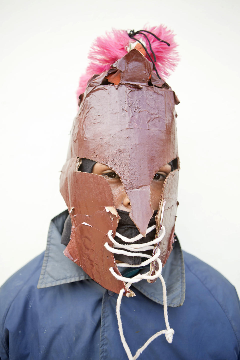 In this April 18, 2014 photo, a youth in a mask poses for a picture during a break while participating in "Los Encadenados," or The Chained Ones procession on Good Friday during Holy Week in Masatepe, Nicaragua. Dressing up in colorful masks and costumes, and dragging chained “Judases” through the streets, residents participate by attaching long chains to people portraying Judas and drag them around, sometimes symbolically kicking and beating them, in punishment for betraying Jesus Christ.(AP Photo/Esteban Felix)