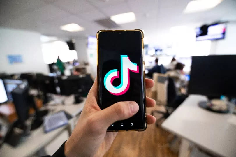 This photograph taken on April 19, 2024 shows a man holding a smartphone displaying the logo of Chinese social media platform Tiktok in an office in Paris (Photo by Antonin UTZ / AFP) (Photo by ANTONIN UTZ/AFP via Getty Images)