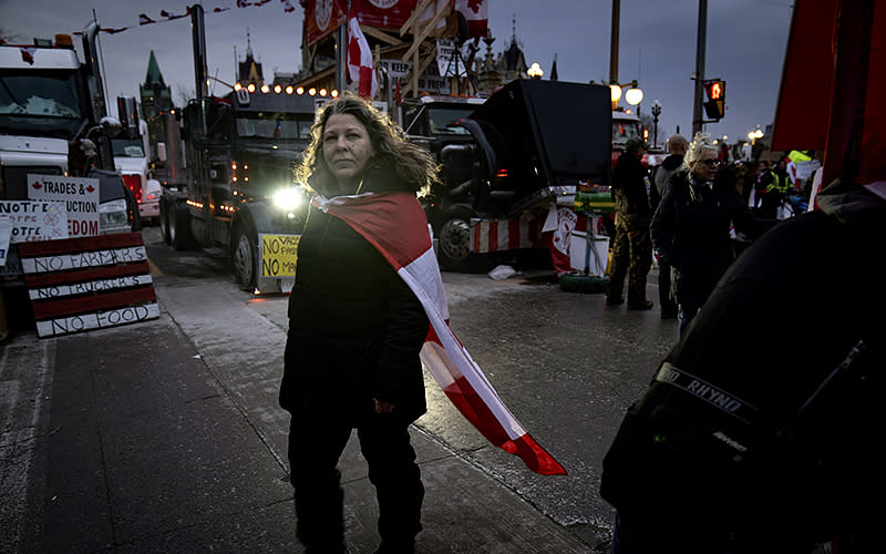 A woman walks among trucks parked in front of the Canadian parliament in protest of COVID-19 restrictions in Ottawa, Ontario, on Feb. 16. <em>Associated Press/Robert Bumsted</em>