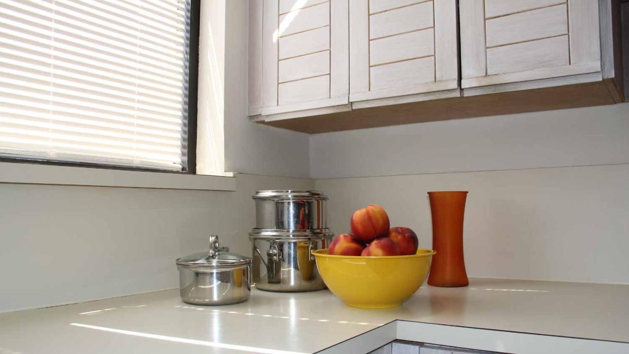 A kitchen counter with cookware and bowl