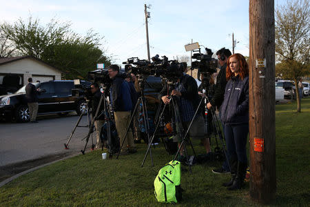 Members of the media stage nearby as law enforcement personnel investigate a home linked to the bomber in Pflugerville, Texas, U.S., March 21, 2018. REUTERS/Loren Elliott