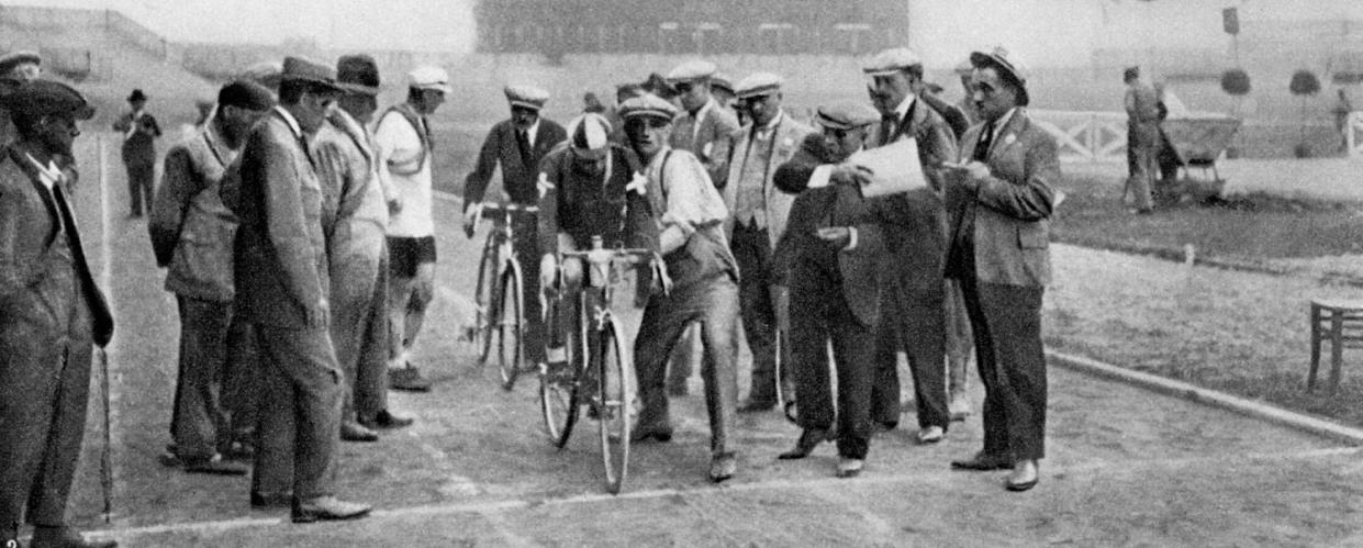 Cyclists, surrounded by team members, volunteers and officials, about to set off for the Individual Time Trials during the 1924 Paris Olympics. (Alamy Stock Photo)