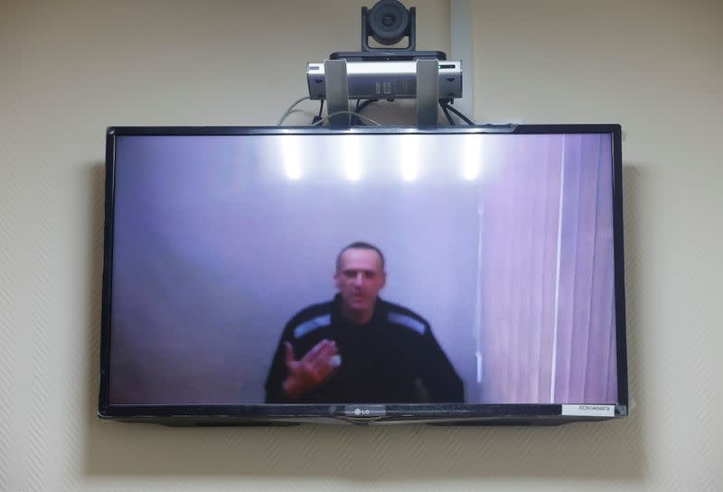 Russian opposition leader Alexei Navalny is seen on a screen via a video link during a hearing in Petushki