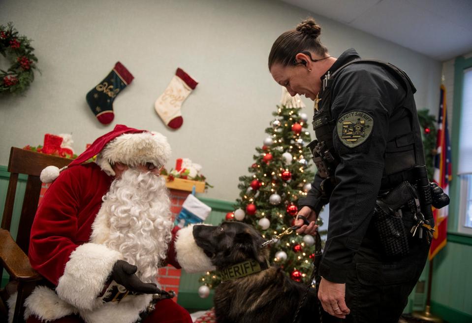 Portage County Sheriff Office Deputy Kelly Moore introduces her partner, Cavo K-9, to Santa at Freedom Town Hall on Dec. 10 in Freedom Township.