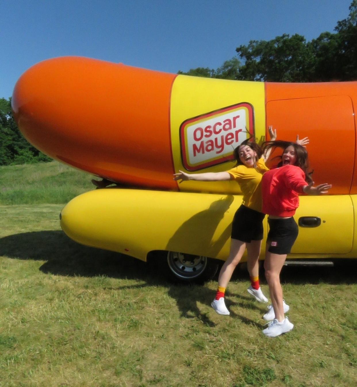 From left to right, Oscar Mayer Wienermobile co-pilots Chloe Van Caeseele aka Chlo-wienie and Mary Clare Kammer aka Chili-Cheese MC strike poses.