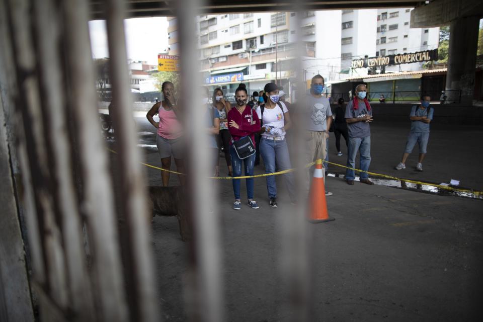 People wait to get into a tent for a free fast coronavirus test amid a quarantine to help stop the spread of COVID-19, at the entrance of a Hospital in Caracas, Venezuela, Wednesday, April 15, 2020. (AP Photo/Ariana Cubillos)