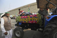 Indian farmers sit on their tractors after arriving at the Delhi-Uttar Pradesh border for Tuesday's tractor rally in New Delhi, India, Monday, Jan. 25, 2021. Thousands of farmers gathered on the borders of Delhi for a massive tractor rally on Tuesday against the three contentious farm laws when India will celebrate its Republic day with a military and cultural parade. The two-month-old old blockade of highways connecting the capital with the country's north continues as the talks have remained deadlocked with the government refusing to scrap the new agricultural reform laws which the farmers say will benefit large corporations. (AP Photo/Manish Swarup)