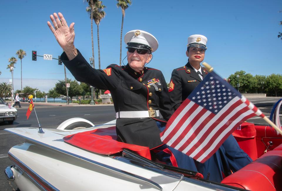 96-year old Marine veteran Frank Wright, left and fellow Marine veteran Mireya Alvarado ride in a car with the Stockton Marine Corps Club in the 4th of July Parade, hosted by the United Veterans Council of San Joaquin County, in downtown Stockton on Monday, July 4, 2022.