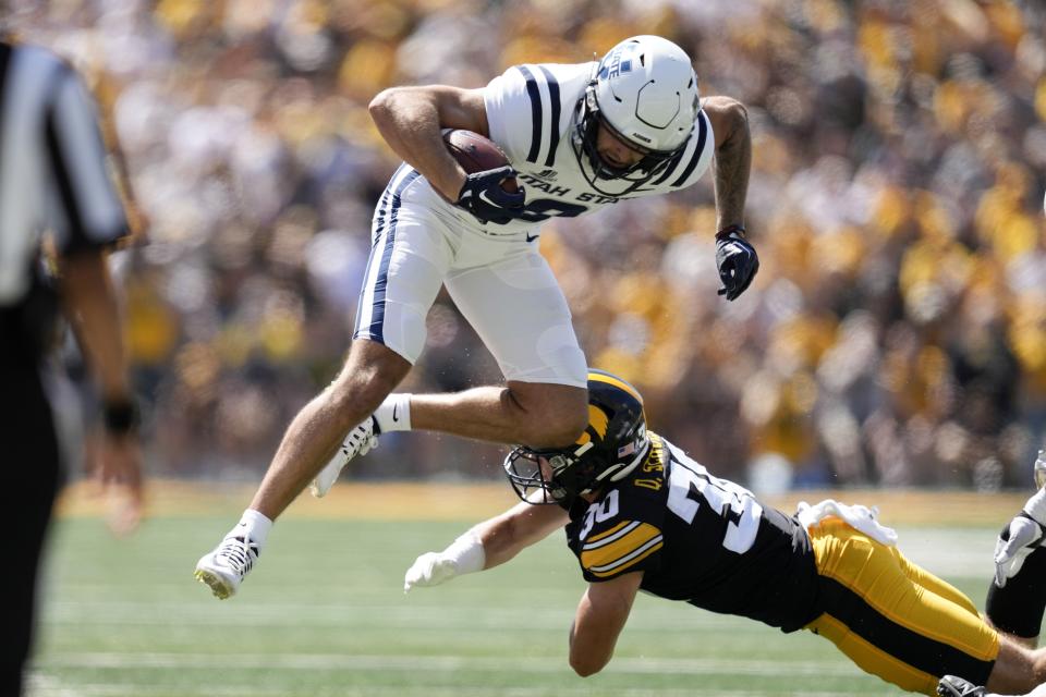Utah State wide receiver Colby Bowman (8) is tackled by Iowa defensive back Quinn Schulte (30) during the first half of an NCAA college football game, Saturday, Sept. 2, 2023, in Iowa City, Iowa. (AP Photo/Charlie Neibergall) | AP