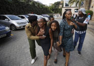 Civilians flee the scene at a hotel complex in Nairobi, Kenya Tuesday, Jan. 15, 2019. An upscale hotel complex in Kenya's capital came under attack on Tuesday, with a blast and heavy gunfire. The al-Shabab extremist group based in neighboring Somalia claimed responsibility and said its members were still fighting inside. (AP Photo/Ben Curtis)