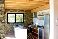 <p>The cozy kitchen features brick walls, an island and beautiful wood-beamed ceilings. (Airbnb) </p>