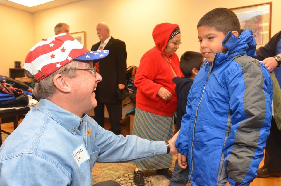 Jerry Angus of the Knights of Columbus helps fit a child with a coat during the fraternal organization’s annual Coats for Kids campaign. | Andy Airriess