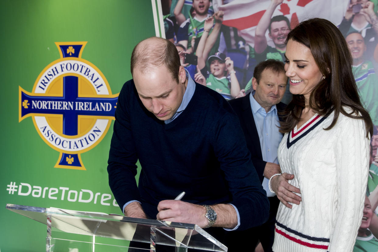 The Duke and Duchess of Cambridge signing the visitors book during their visit to Windsor Park, Belfast as part of their two day visit to Northern Ireland.